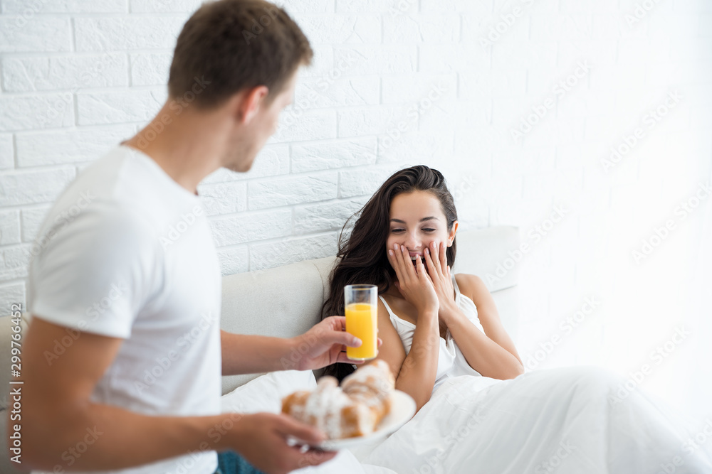 young man prepared tasty breakfast - croissants and orange juice in bed for his beloved wife looking happy morning family idyll young man prepared tasty breakfast - croissants and orange juice in bed for his beloved wife looking happy morning family idyll