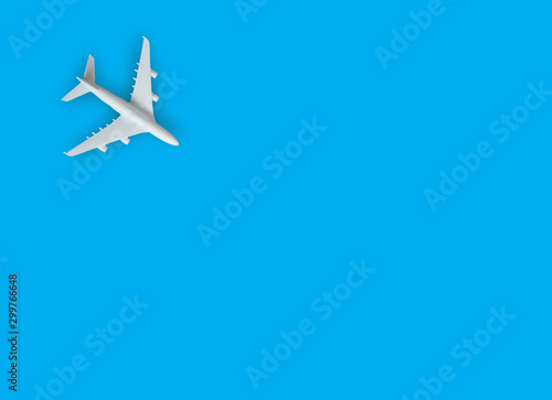 Miniature toy airplane white on blue background.