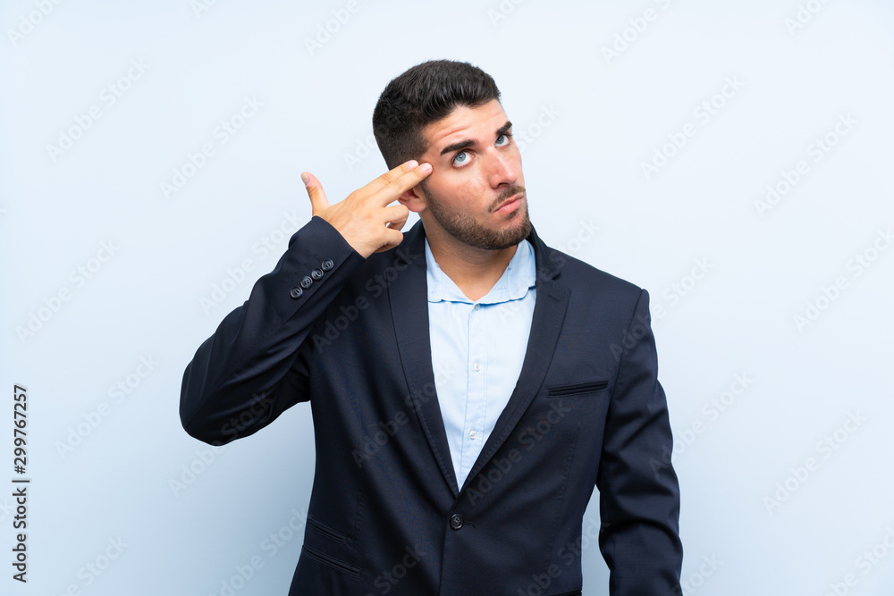Handsome man over isolated blue background with problems making suicide gesture Handsome man over isolated blue background with problems making suicide gesture
