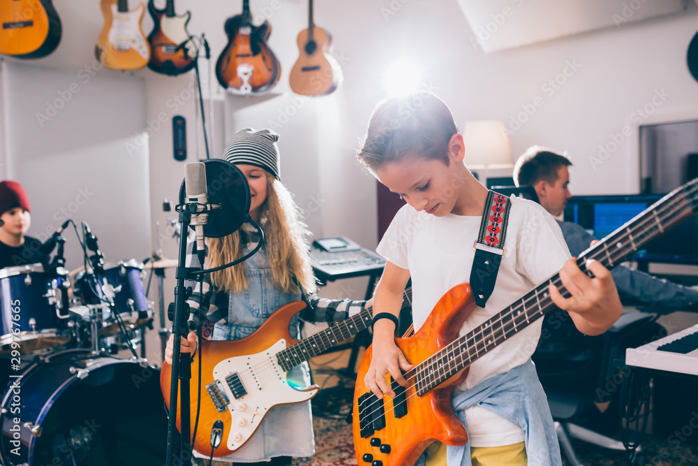 Young kids rock band in music studio - obrazy, fototapety, plakaty 
