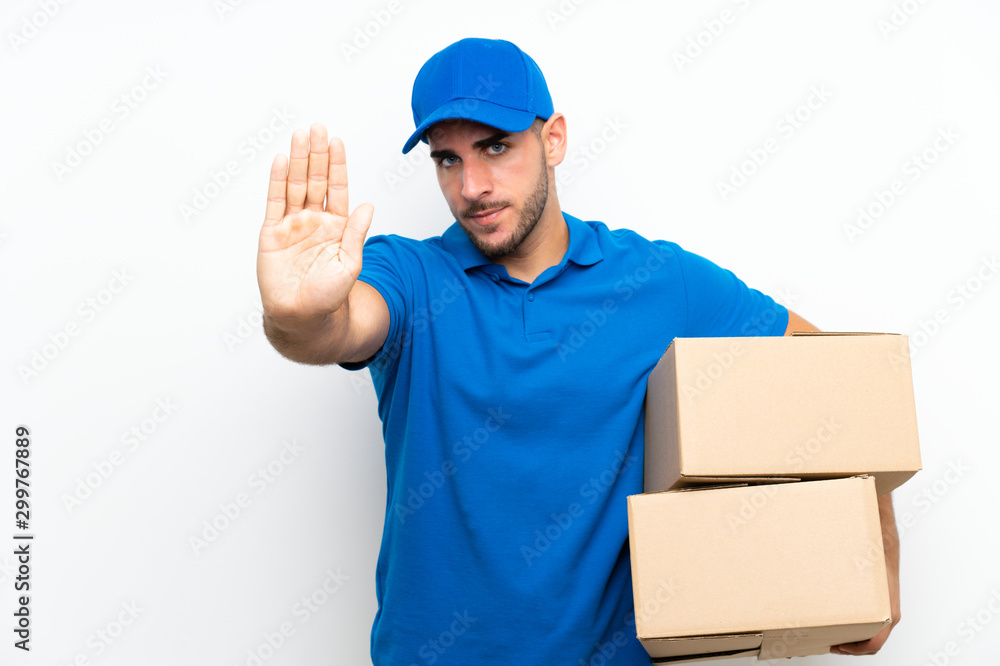 Delivery man over isolated white background making stop gesture with her hand Delivery man over isolated white background making stop gesture with her hand