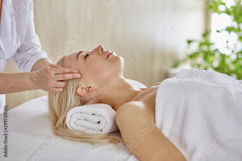 Beautiful woman with closed eyes getting a massage in the spa salon