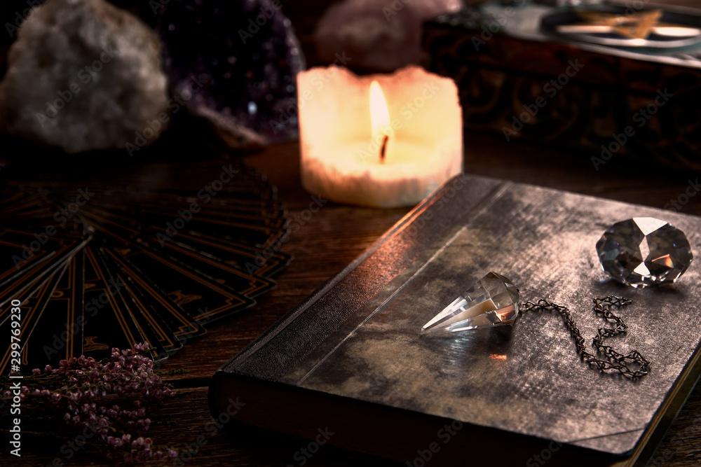 Still life with burning candle on old wooden table top, black fortune teller card, magic book and pentagram box - obrazy, fototapety, plakaty 