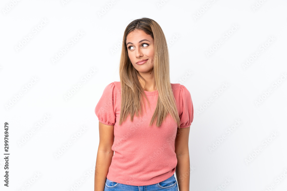 Young blonde woman over isolated white background making doubts gesture looking side Young blonde woman over isolated white background making doubts gesture looking side