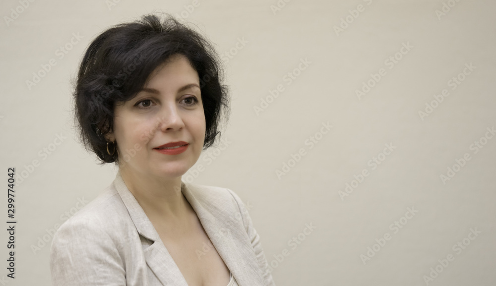 Pretty business woman, successful confidence portrait with copy space. Attractive middle aged woman in business suit against concrete beige wall. Pretty business woman, successful confidence portrait with copy space. Attractive middle aged woman in business suit against concrete beige wall.
