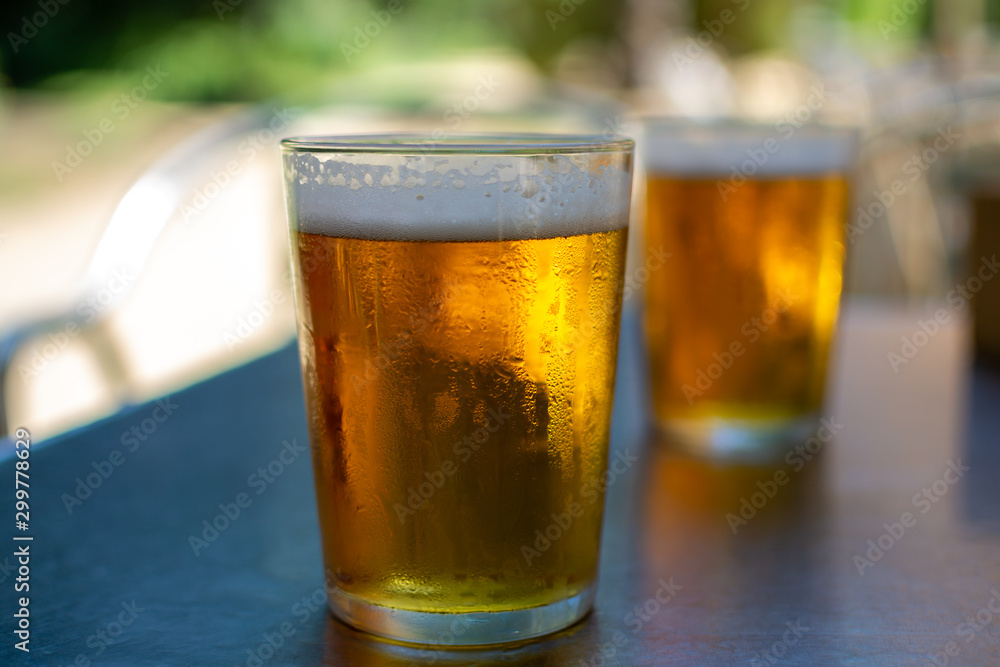Cold amber color light spanish beer served in glass in outdoor cafe in sunny Andalusia, Spain Cold amber color light spanish beer served in glass in outdoor cafe in sunny Andalusia, Spain