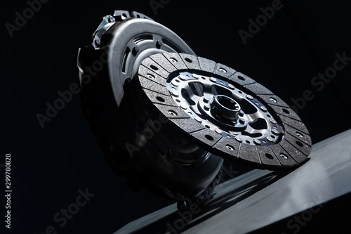 Close-up picture of a part of car, black clutch disk isolated on black background photo