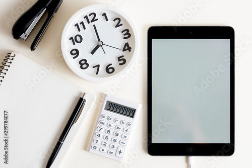 Creative desktop.Modern design, white colors. Office, school ,college . Alarm clock and school, college, business  object. Tablet in the side . Copy space.