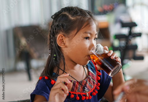 Young girl is drinking soft drink.