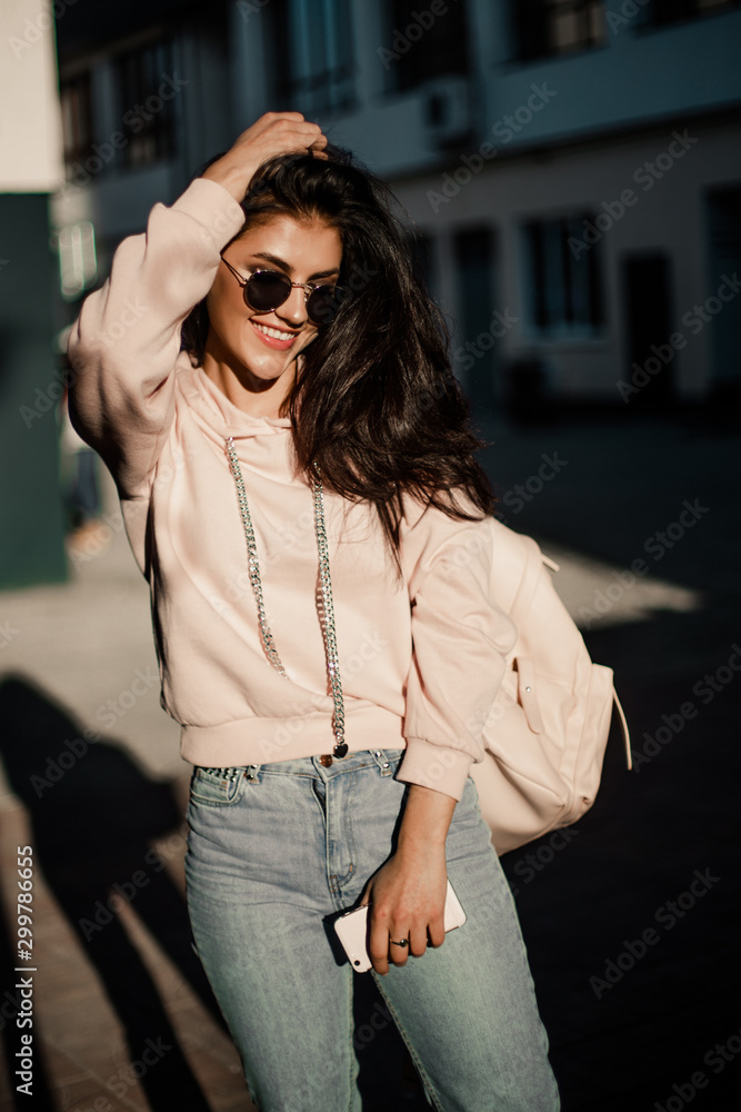 Fototapeta premium Woman walking with phone on the streets.