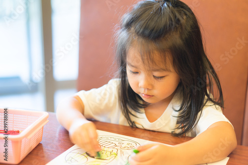 4 years old kid girl.Fine motor skills development concept.Little asian girl learning painting drawing in restaurant.