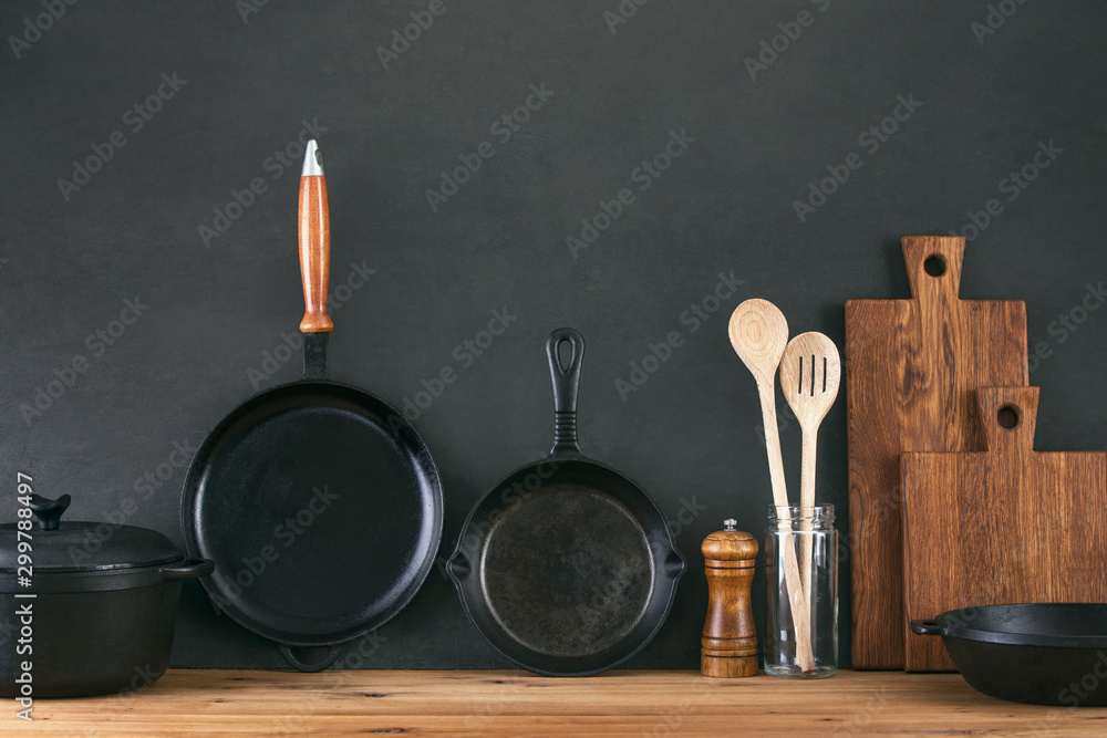 Kitchen utensils dark background with cast iron black kitchenware Stock