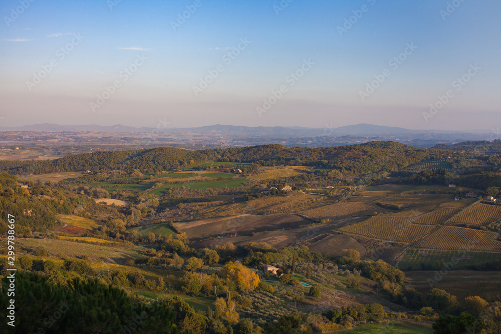 View from the top of mountain in Italy overlooking a Italian valley rolling hills blue skies 