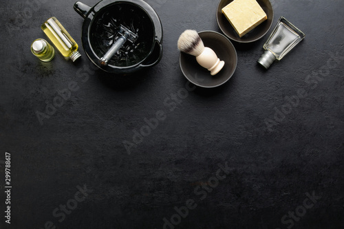 Shaving accessories set on a dark background, top down view