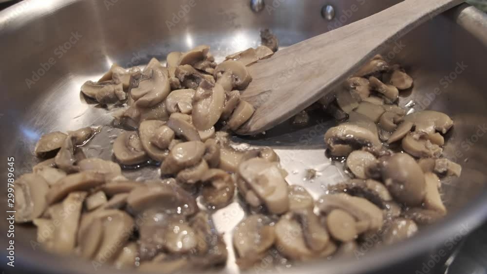 Frying mushrooms low angle zoom in, shallow depth of field. Frying mushrooms low angle zoom in, shallow depth of field.