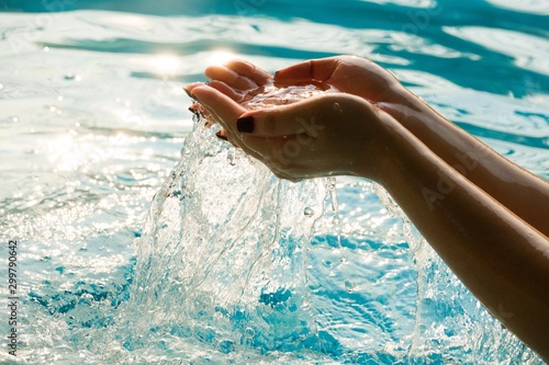Woman hands in water inviting you over sunset golden rays