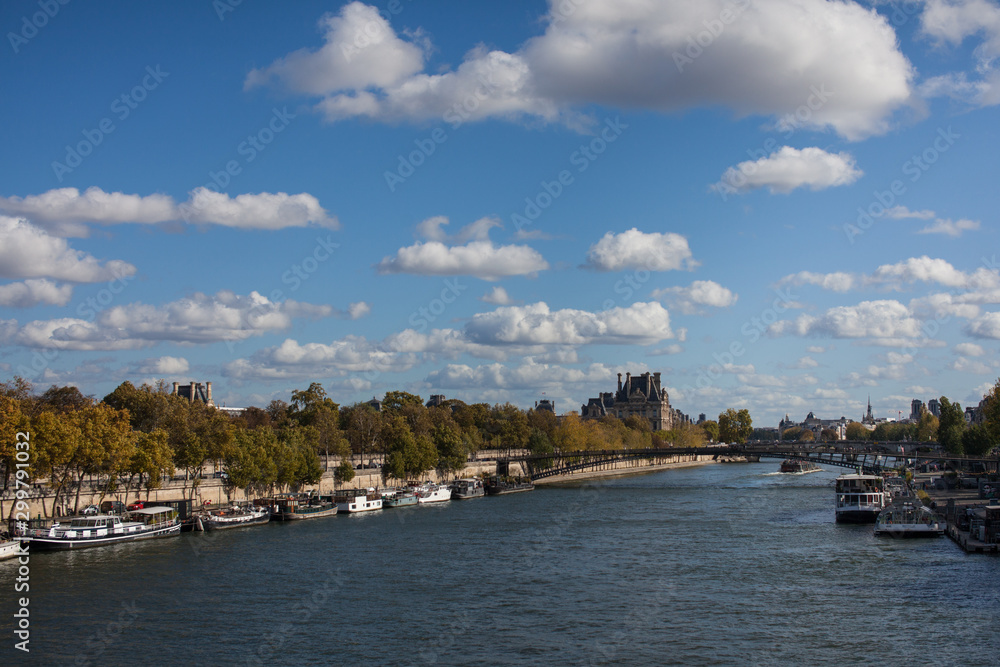  View of river channel in Paris France fluffy cloudy blue sky 