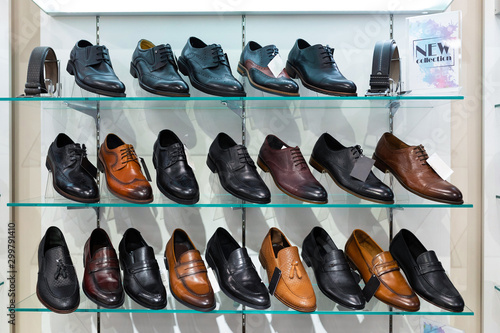 Glass shelves with man's shoes in a shop