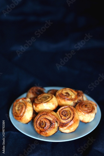 Homemade cinnamon rolls on a plate. Selective focus, dark background.