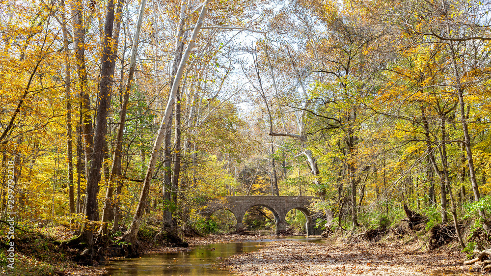 autumn landscape with a stone bridge over a stream autumn landscape with a stone bridge over a stream