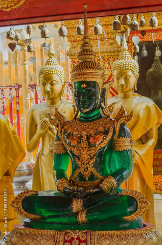 Stunning emerald buddha sculpture in a peaceful meditative posture in a golden Buddha temple