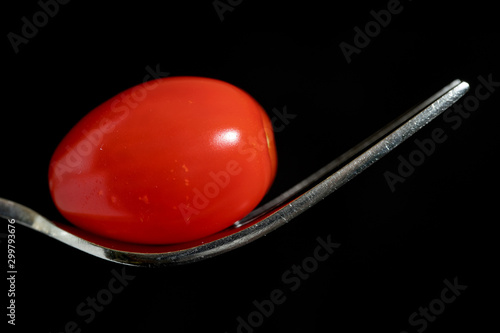 Styling food on a fork with a single tomato, mozzarella ball, basil, balsamic vinegar