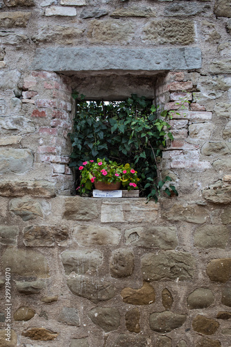 Old window with flowers stone brick wall 