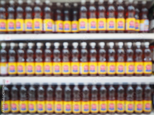 Blur Supermarket fish sauce bottles on shelves background, Many fish sauce bottles sale on the shelf in a supermarket, as blurred effect background.