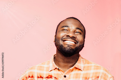 Portrait of a young man with big smile looking up, isolated on colorful background
