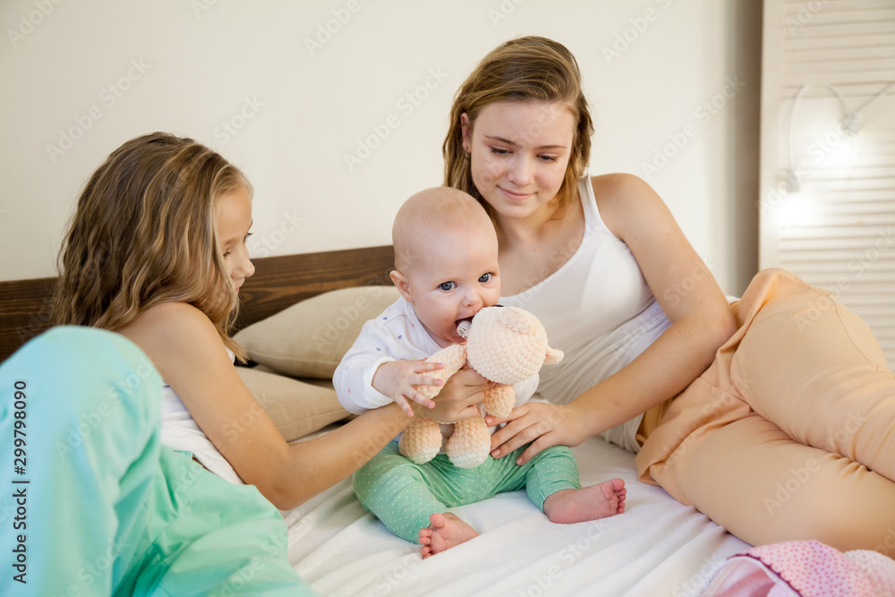three little girls sisters in the bedroom on the bed three little girls sisters in the bedroom on the bed