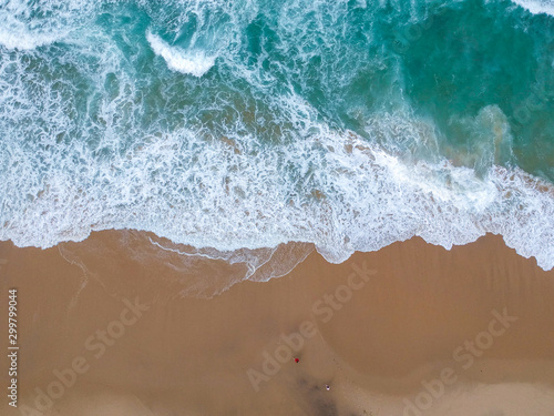 Sand beach aerial, top view of a beautiful sandy beach aerial shot with the blue waves rolling into the shore