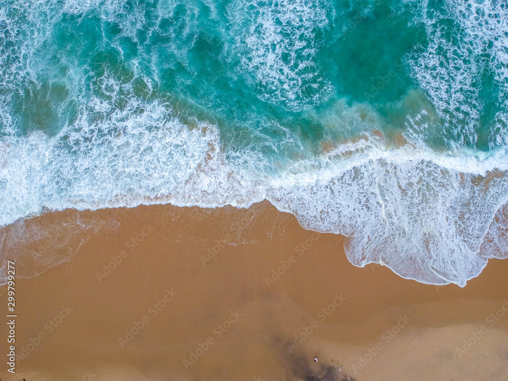 Sand beach aerial, top view of a beautiful sandy beach aerial shot with the blue waves rolling into the shore