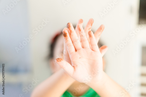 Little girl hands painted in colorful paints.