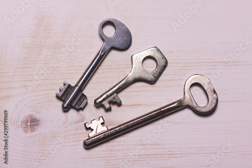three iron key lies on a white wooden surface © Антон Винокуров