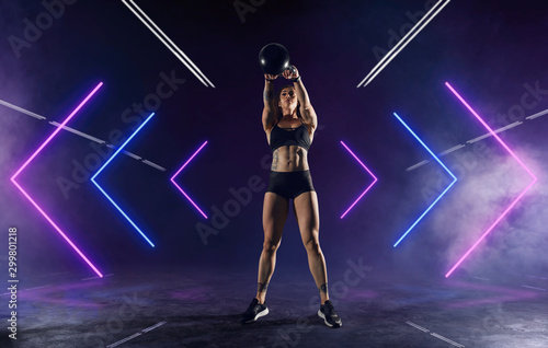 Athletic girl does exercises using sports equipment in a gym.