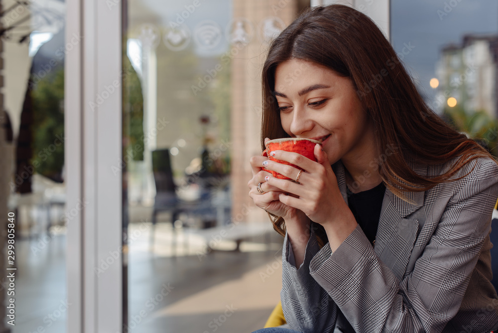 Pretty young fashion woman looking cheerful and happy chatting on social media on smart phone app while drinking coffee in urban city. In lifestyle mobile use and online app and technology concept. Pretty young fashion woman looking cheerful and happy chatting on social media on smart phone app while drinking coffee in urban city. In lifestyle mobile use and online app and technology concept.