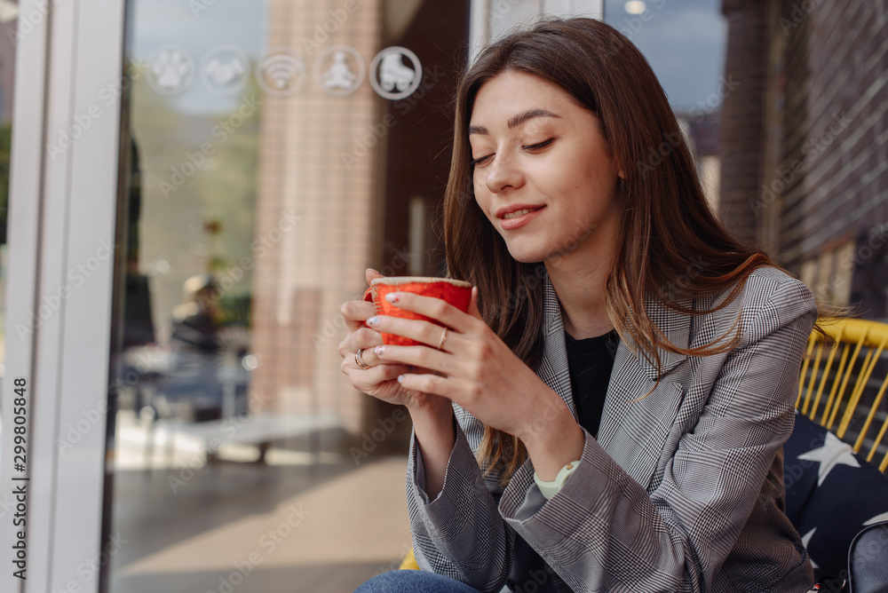 Pretty young fashion woman looking cheerful and happy chatting on social media on smart phone app while drinking coffee in urban city. In lifestyle mobile use and online app and technology concept. Pretty young fashion woman looking cheerful and happy chatting on social media on smart phone app while drinking coffee in urban city. In lifestyle mobile use and online app and technology concept.