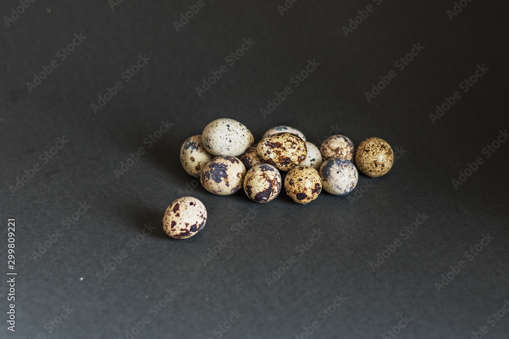 Beautiful spotted quail eggs on black and grey background. Easter holiday. Beautiful spotted quail eggs on black and grey background. Easter holiday.
