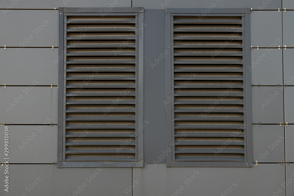 Front view of dirty dark grey ventilation grill in matte metal wall Front view of dirty dark grey ventilation grill in matte metal wall