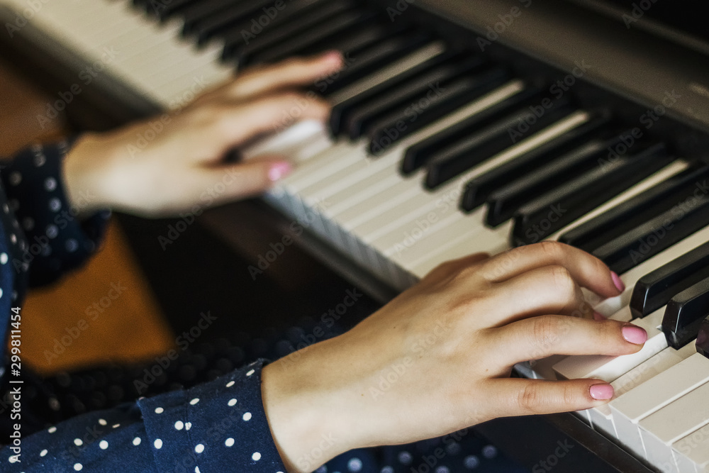 Fototapeta premium Hands of the girl pianist on the keys during the game