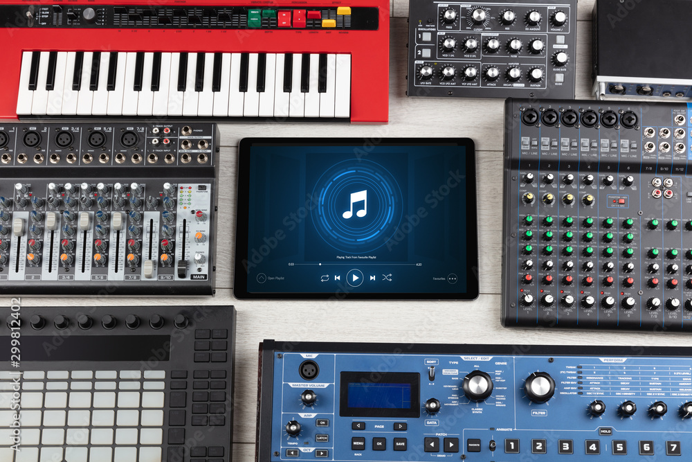 Playing song on tablet with electronic music instruments around Playing song on tablet with electronic music instruments around