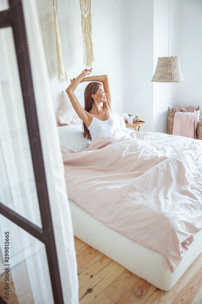 Cheerful young female sitting on the bed Cheerful young female sitting on the bed