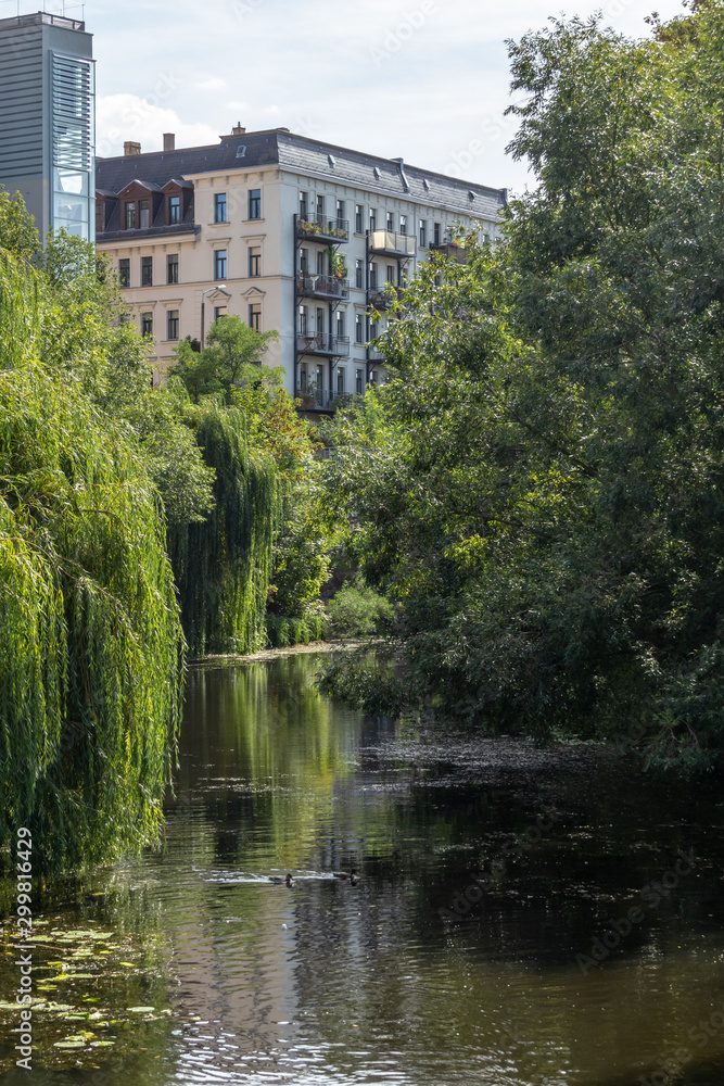 View of historic and modern buildings and churches on the Karl Heine canal in Leipzig / Germany with a newly created bicycle and hiking trail
