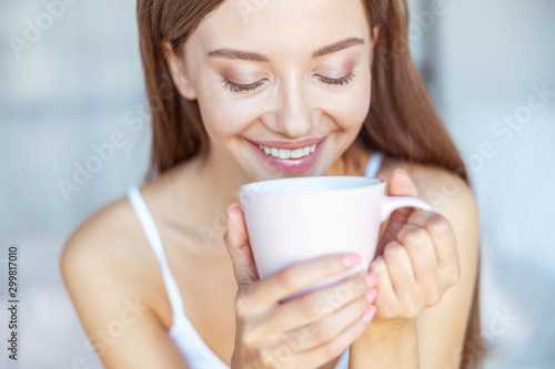 Portrait of charming brunette that looking into her cup