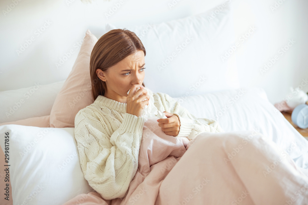 Ill young female person wiping her nose