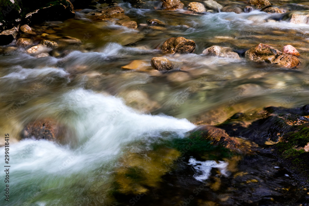 View to scenic mountain river with rapid and noisey stream of green-blue water and rocks in natural park in Austria. Natural beauty concept. Mountain stream among the stones. View to scenic mountain river with rapid and noisey stream of green-blue water and rocks in natural park in Austria. Natural beauty concept. Mountain stream among the stones.