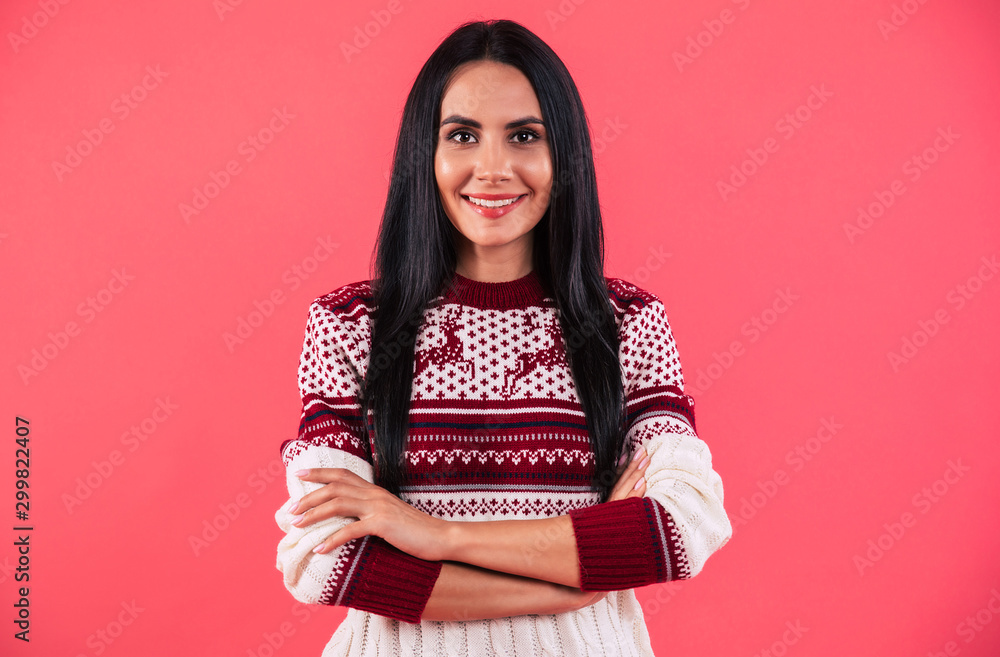 Excitement. Amazing young girl in knitted reindeer sweater is posing with folded arms, looking at the camera, smiling with joy. Excitement. Amazing young girl in knitted reindeer sweater is posing with folded arms, looking at the camera, smiling with joy.