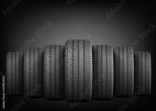 Black rubber tires standing in row line on dramatic dark background