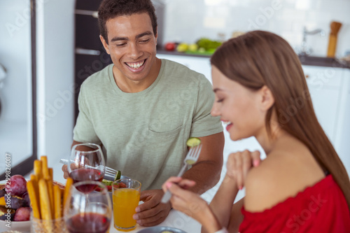 Positive delighted man and woman eating vegetables