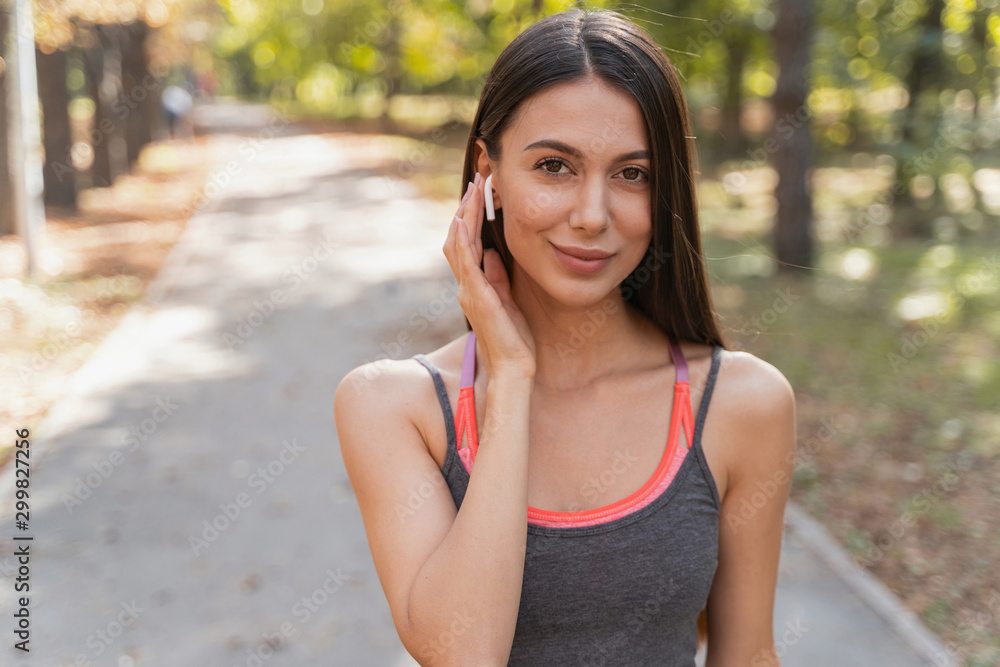 Cheerful woman putting some music on before jogging Cheerful woman putting some music on before jogging